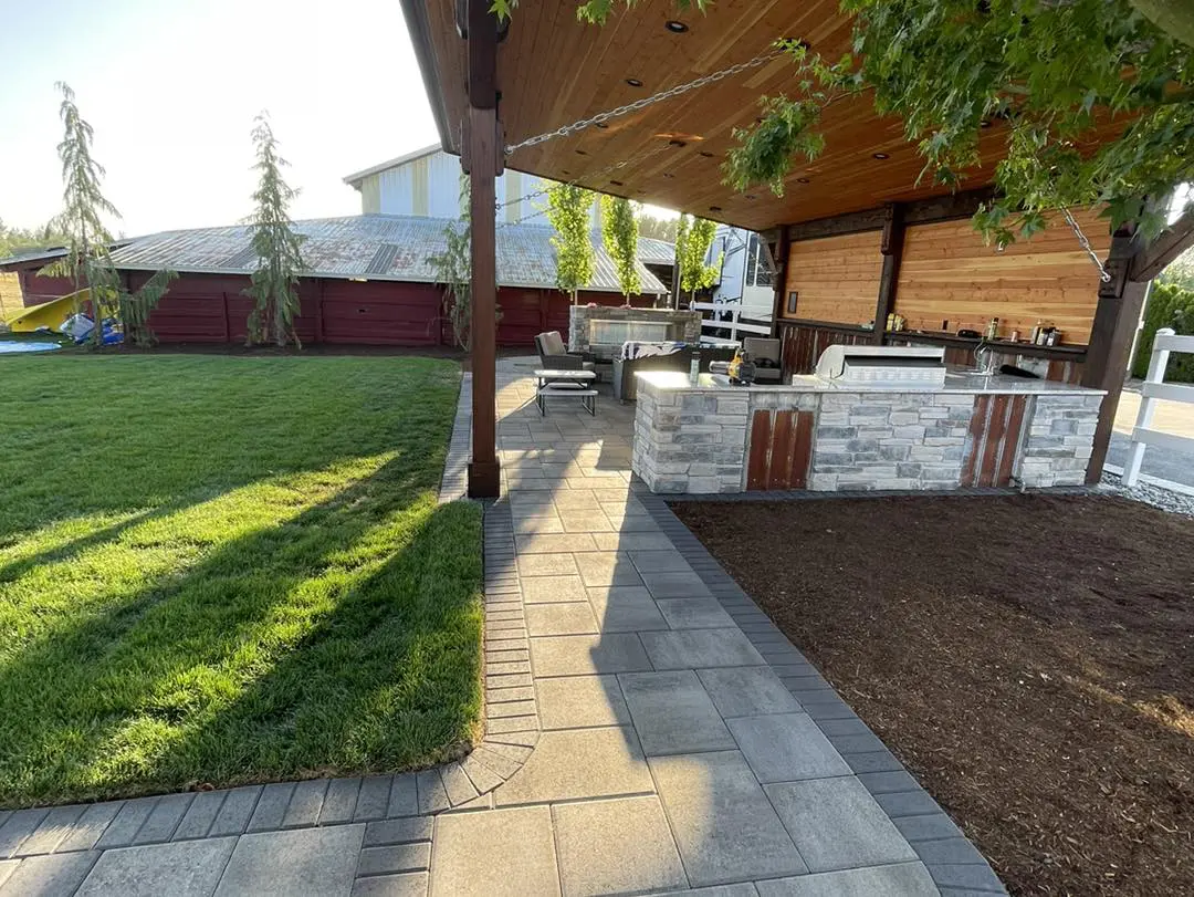 A patio with an outdoor grill and seating area.