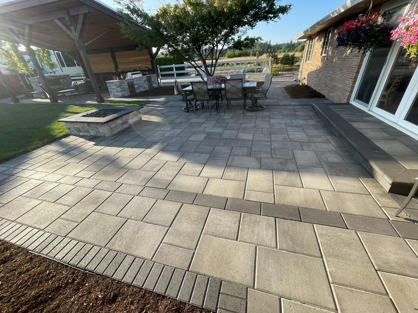 A patio with pavers and benches in the middle of it.