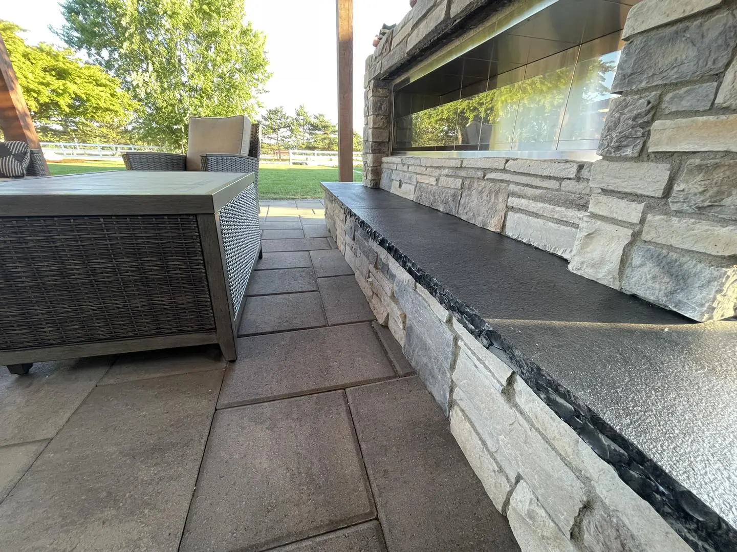 A patio with a bench and fire place