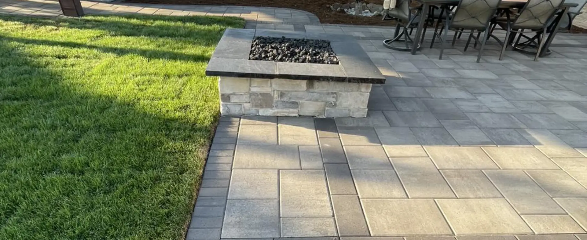 A fire pit sitting on top of a brick patio.