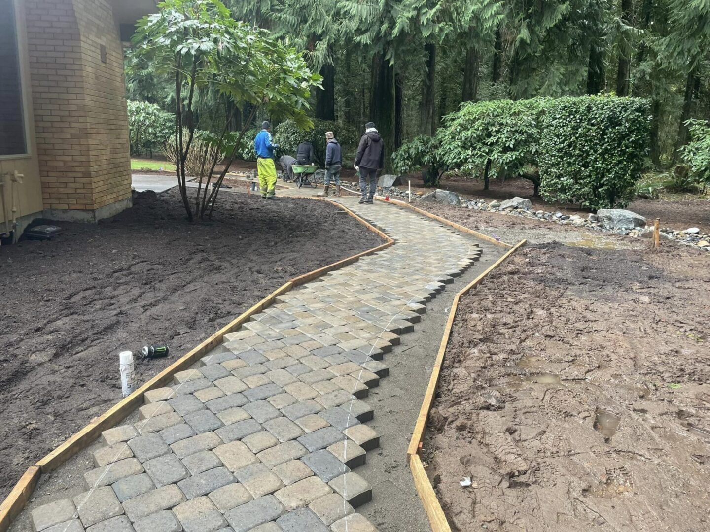 A walkway with brick and stone is being built.