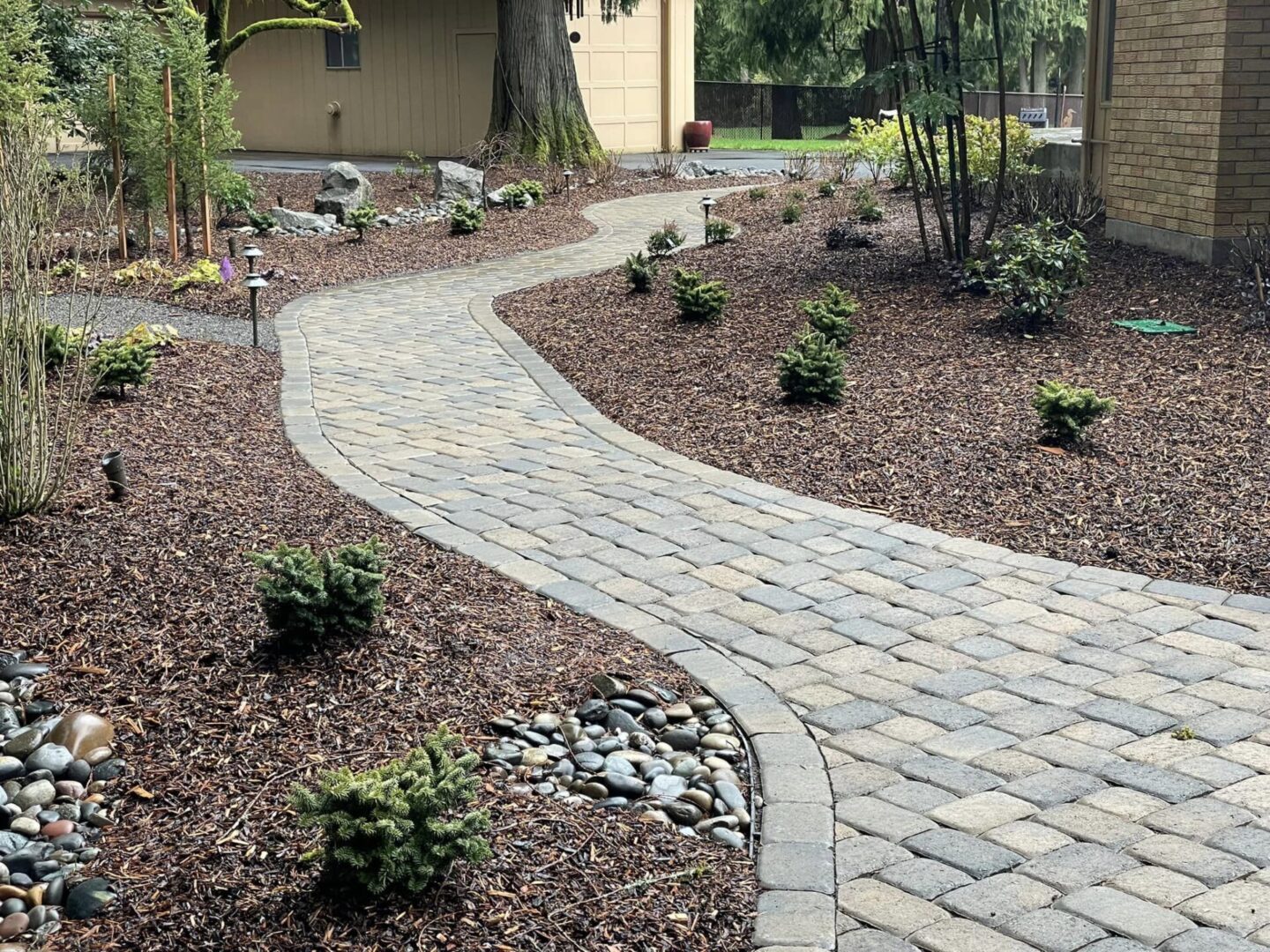 A walkway with a brick pattern and stone border.