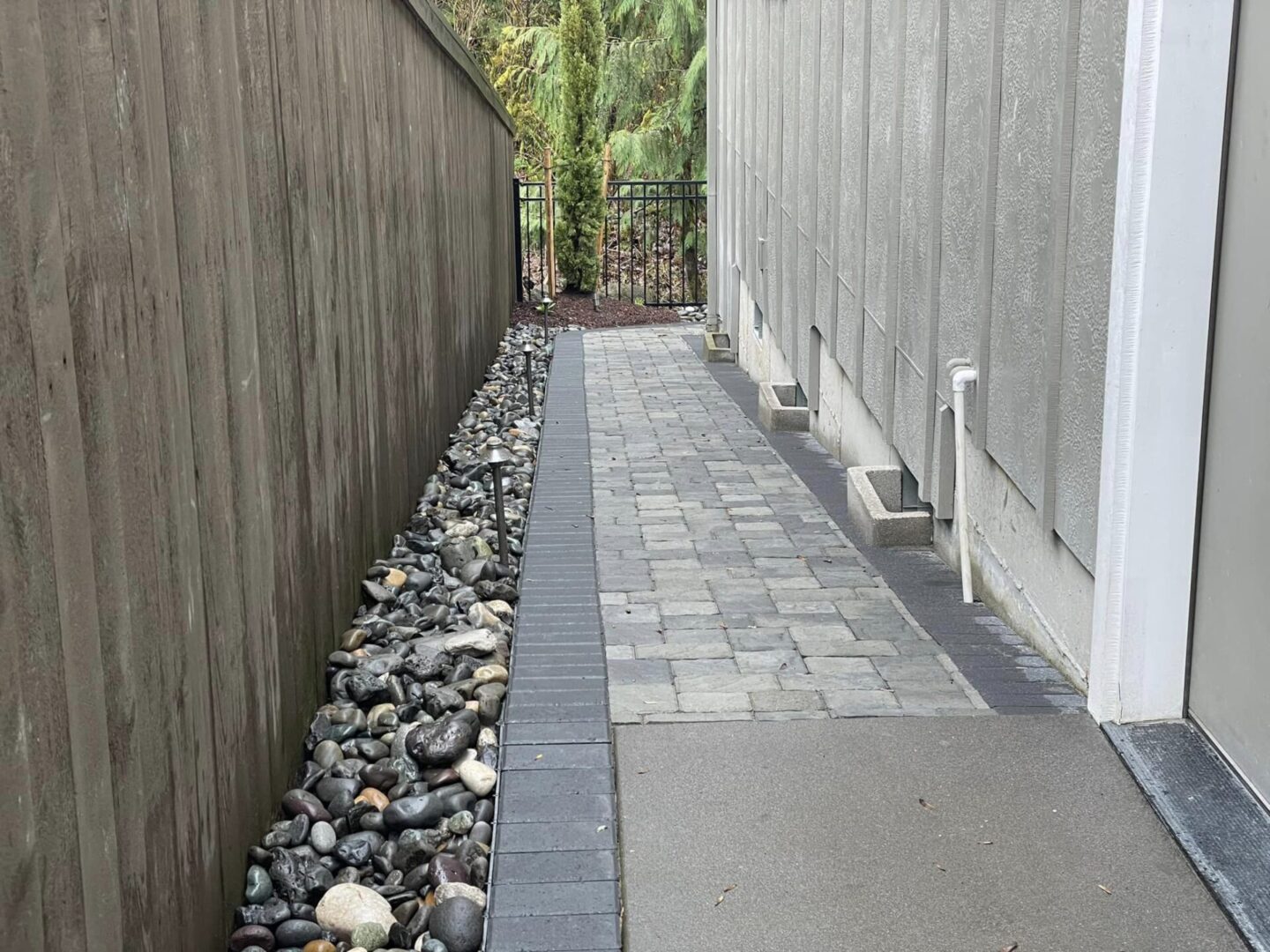 A walkway with stones and a sidewalk in the middle.