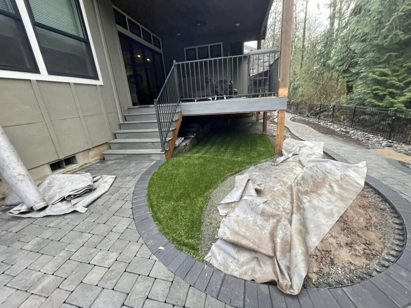 A patio with grass and brick steps in the middle of it.