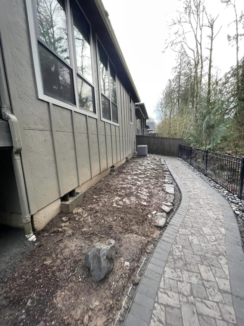 A house with a stone walkway and a rock wall.