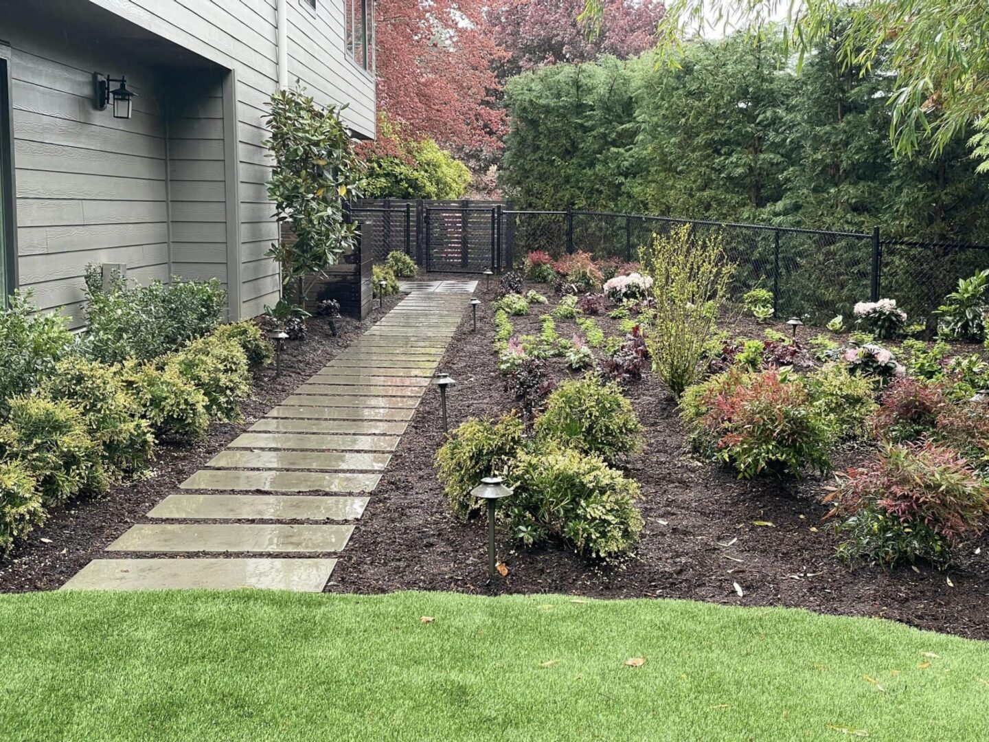 A garden with flowers and grass in the middle of it.