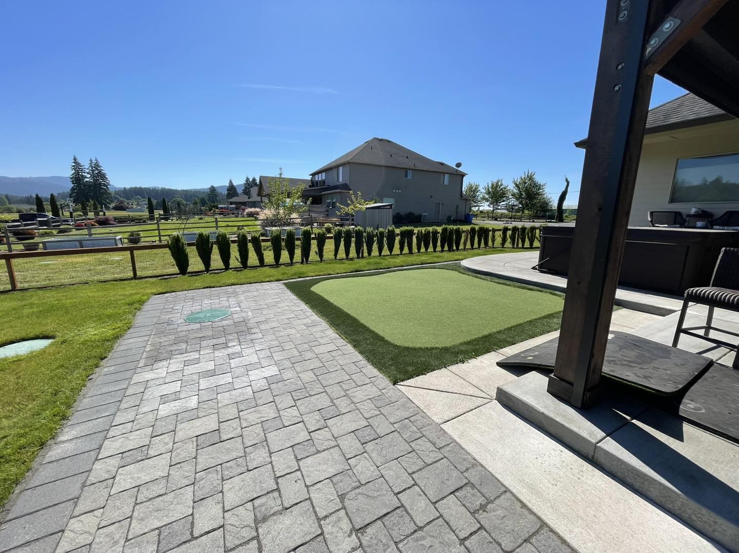 A backyard with a putting green and a walkway.