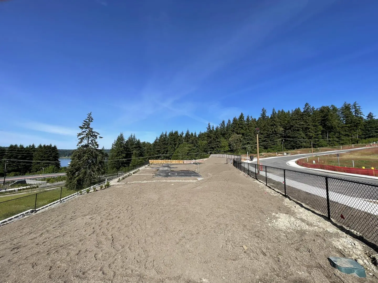 A dirt field with trees in the background