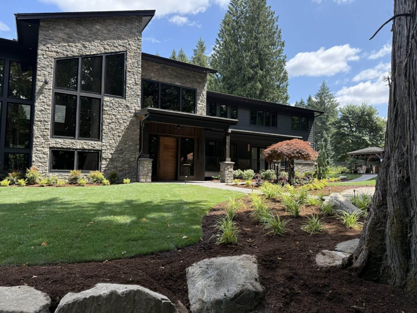 Modern stone house with landscaped garden.